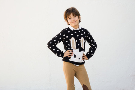 Seven years old girl with short hair smiling on a white wall