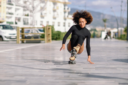 Black woman on roller skates falling to the ground