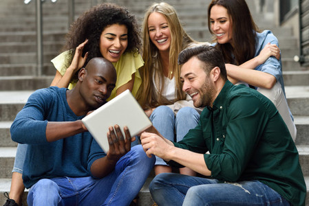 Multi ethnic group of young people looking at a tablet computer
