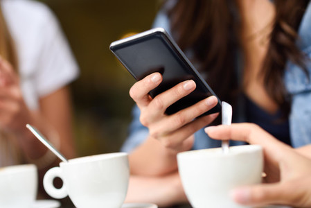 Young girl hand with modern smartphone device in cafe bar