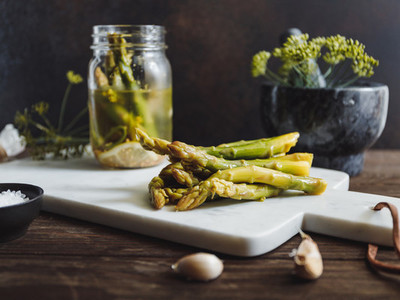 Pickled asparagus on a white marble tray Seasonal canning vegetable recipe