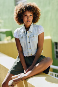 Black woman afro hairstyle wearing casual clothes in urban bac