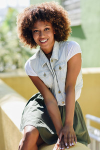 Young black woman afro hairstyle smiling in urban background