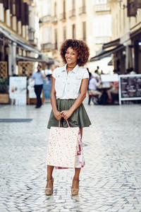 Black woman afro hairstyle with shopping bags in the street