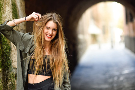 Happy blonde girl smiling in urban background
