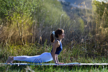 Young beautiful woman doing yoga in nature