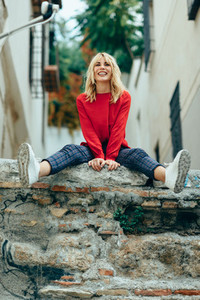 Smiling blonde girl with red shirt enjoying life outdoors