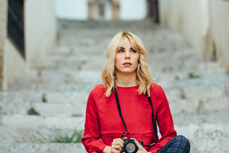 Young woman taking photographs with an old camera in a beautiful