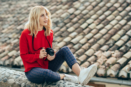 Young woman taking photographs with an old camera in a beautiful city