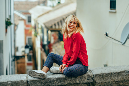 Smiling blonde girl with red shirt enjoying life outdoors