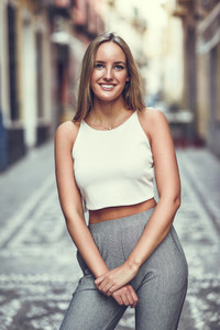Beautiful young blonde woman smiling in urban background