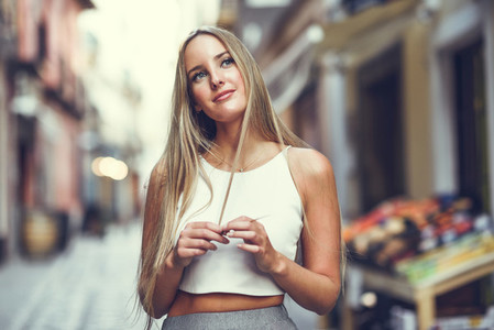 Beautiful young blonde woman in urban background