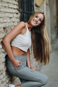 Smiling blonde girl with straight hair in urban background