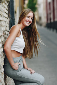Smiling blonde girl with straight hair in urban background