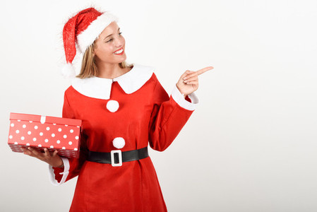 Blonde woman in Santa Claus clothes smiling with gift box