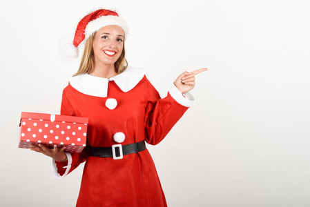 Blonde woman in Santa Claus clothes smiling with gift box