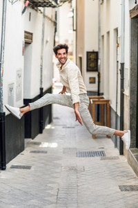 Young happy man jumping in the street