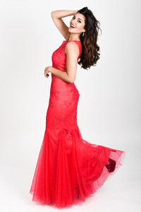 Young woman wearing long red dress on white background