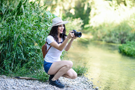 Hiker woman taking photographs with a mirrorless camera