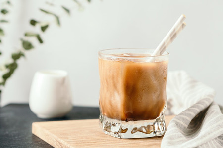 Refreshing iced latte in a glass with straws in a modern kitchen