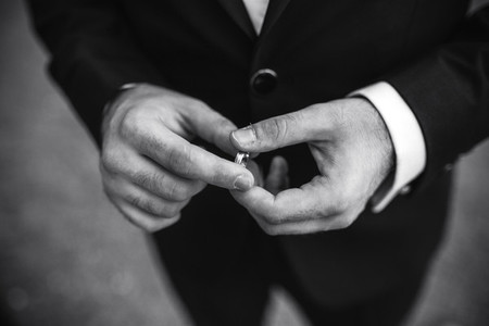 groom holding a wedding ring