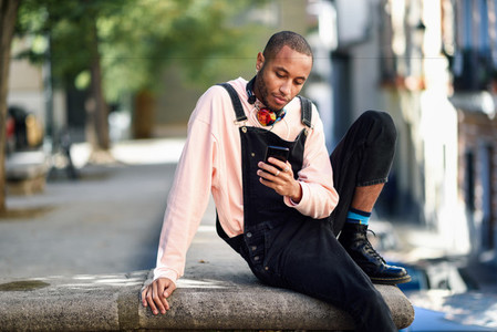 Young black man using smart phone outdoors
