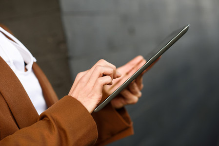 Businesswoman with tablet computer standing outside of an office
