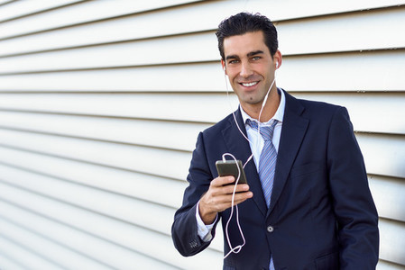 Businessman wearing blue suit and tie using a smartphone