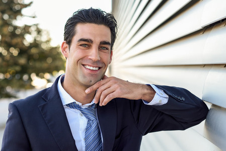 Young businessman wearing blue suit and tie in urban background