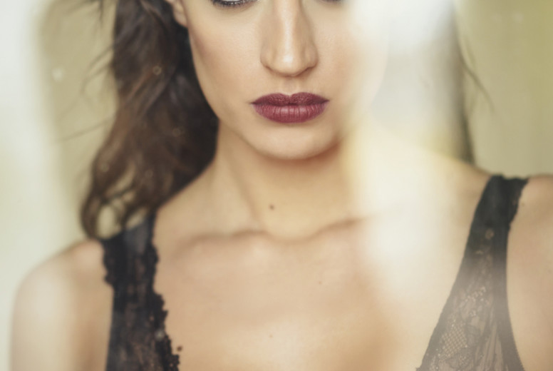 Young brunette woman looking through the window