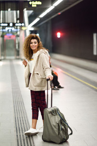 Young arabic woman waiting her train in a subway station