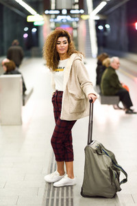 Young arabic female tourist waiting her train in a subway statio