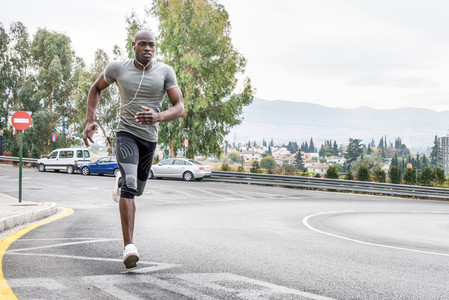 Black man running outdoors in urban road