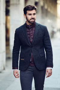 Young bearded man smiling in urban background wearing british el