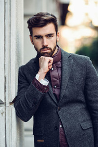 Young bearded man in urban background wearing british elegant su
