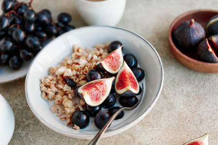 Close up view of a breakfast bowl with granola blue grape and fig slices Healthy vegan eating