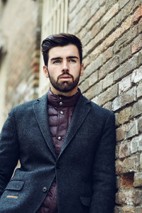 Young bearded man in urban background wearing british elegant su