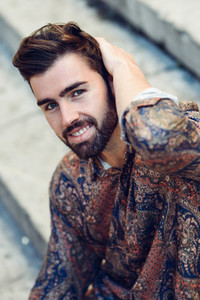 Young bearded man model of fashion wearing shirt in urban back
