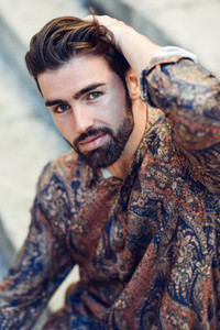 Young bearded man model of fashion wearing shirt in urban back