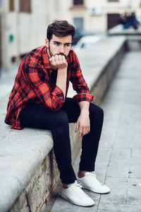 Young bearded man model of fashion in urban background wearing