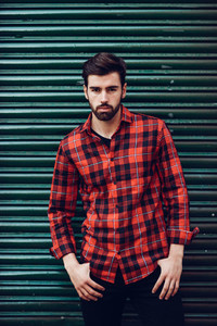 Young bearded man model of fashion wearing a plaid shirt with
