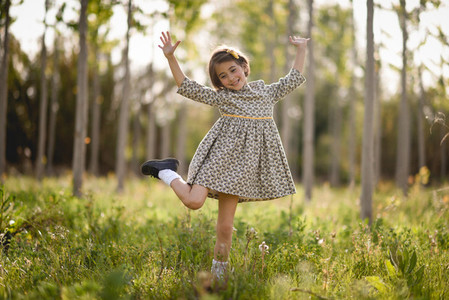 Little girl in nature field wearing beautiful dress