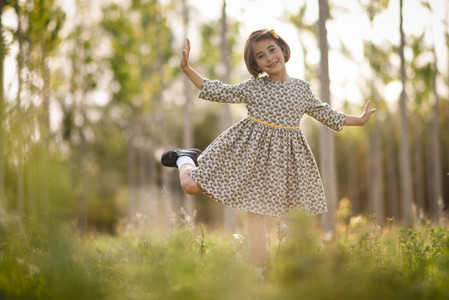 Little girl in nature field wearing beautiful dress