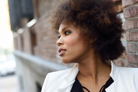 Young black woman with afro hairstyle standing in urban backgrou
