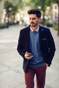 Man in the street in formalwear with smartphone in his hand