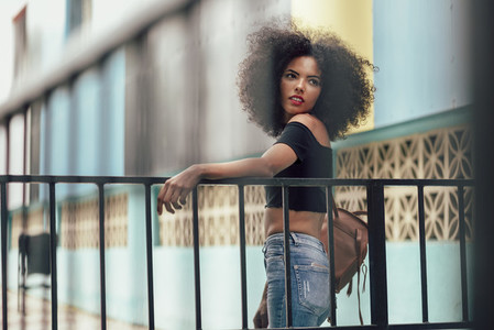 Young mixed woman with afro hair standing on the street