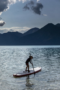 Boy paddleboarding on sunny  idyllic lake  Walchensee  Bavaria  Germany