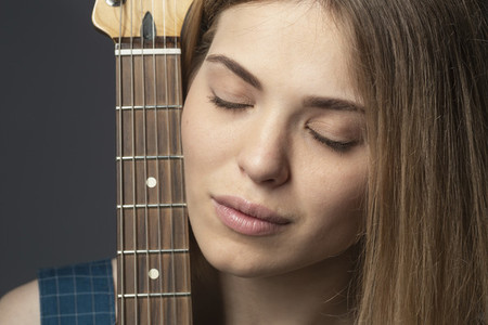 Close up portrait serene young woman with guitar