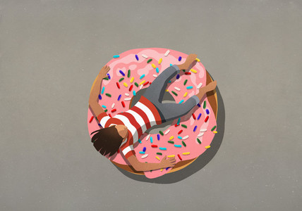 Girl relaxing on large donut with sprinkles