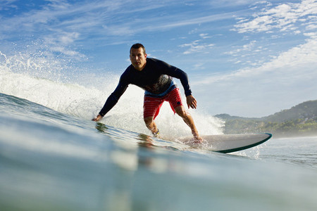 Male surfer riding ocean wave 02